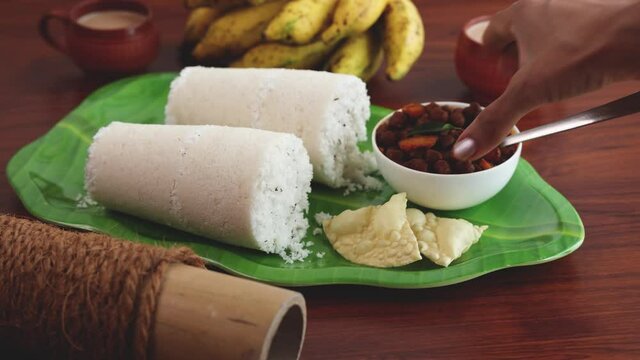 Rice Puttu white Pittu , Kadala Chickpea curry , milk tea , popular South Indian breakfast steamed rice cake 4K slow motion video footage Kerala Tamil Nadu India Sri Lanka. rice flour grated coconut  