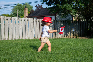 Kid citizen celebrating Canada Day holiday on first day of July. Canadian flag