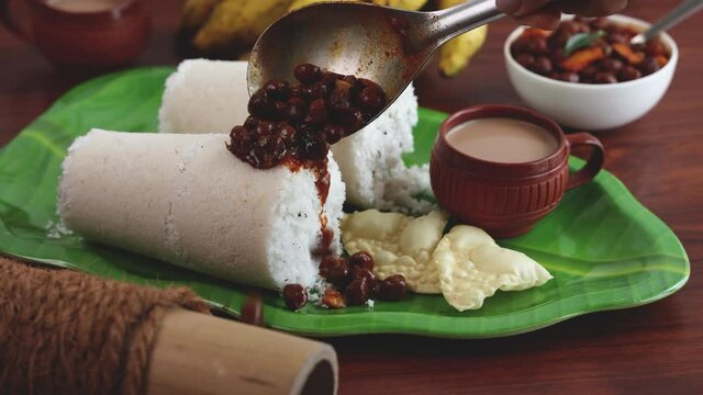 Rice Puttu white Pittu , Kadala Chickpea curry , milk tea , popular South Indian breakfast steamed rice cake 4K slow motion video footage Kerala Tamil Nadu India Sri Lanka. rice flour grated coconut  
