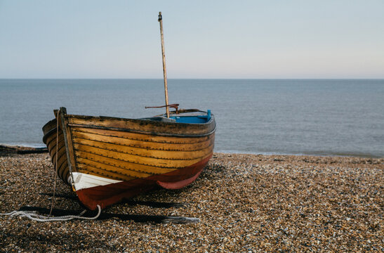 Traditional small wooden fishing boat on the shore.