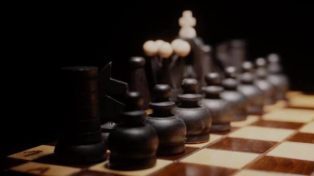 Black chess pieces standing in row. Chess board ready to play. Logic game, challenging task.