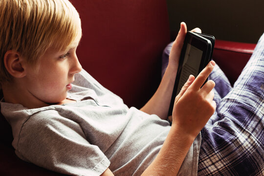 A young boy reading an E Reader