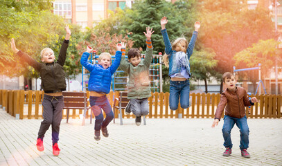 Happy kids jump and play outside. High quality photo