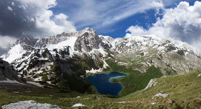 Heart shaped lake in cold mountains covered by snow