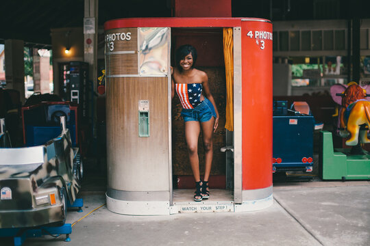 Black girl in Americana top standing in a Photo Booth