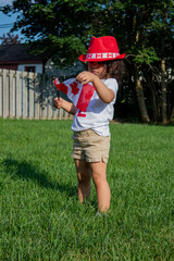 Kid citizen celebrating Canada Day holiday on first day of July. Canadian flag