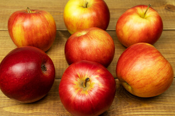 Red ripe apples on wooden table, close up.