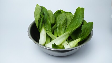 Bok choy (chinese cabbage) or pak choi  on the stainless plate on white