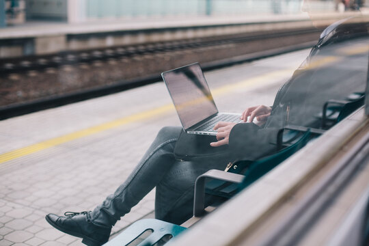 Woman working on her laptop on a train station