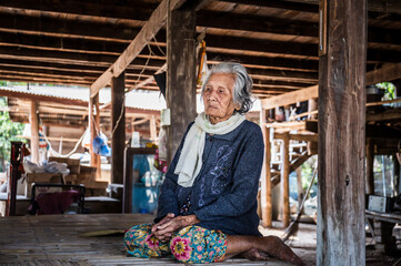 Fototapeta na wymiar Portrait of Asian senior women, Older woman with short grey hair sitting at home in the countryside of Thailand, Asian older people in the rural of asia
