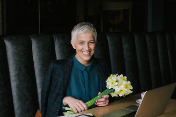 Smiling Senior Businesswoman Holding A Flower Bouquet