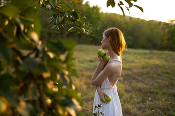 woman with green apples near tree and white dress summer nature