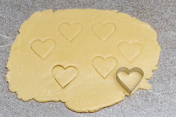 Making homemade heart shaped cookies. Dough with cooked cookie cutters and a heart shaped cookie...
