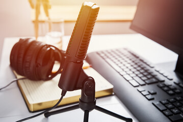 Microphone, headphones and computer monitor on table. Online podcast concept