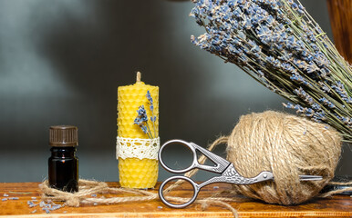 Composition with a candle, aromatic oil, dry lavana flowers. Production of candles from yellow beeswax with smell. DIY