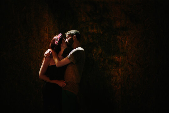 A young couple embraces in a kiss during a quiet moment on the street