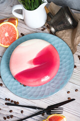 Red and white cake with orange filling. Nearby on a black table are ingredients oranges, nuts. Rustic style