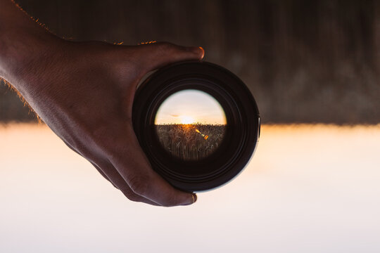 View through spyglass lens to the sunset on the dry field