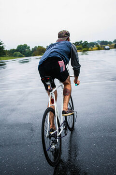 Hip young man rides his fixed gear in the rain