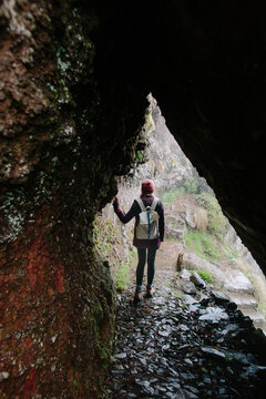 A woman walking on a path up in the mountains.