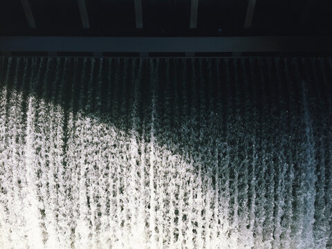 Fast moving water flowing over dam barrier