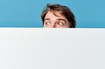 man peeking out from behind banner cropped view advertisement copy space blue background