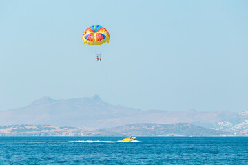 Multicolored parasail wing pulled by a boat. Sea summer recreation - Bodrum, Turkey.