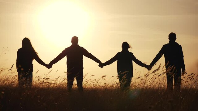 teamwork. team community hold hands together silhouette at sunset unity. group of business people hands. teamwork a workers carry out one mission go the goal. team in the company working partnership