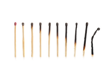 One whole match among burnt out ones on white background. Concept of life stages