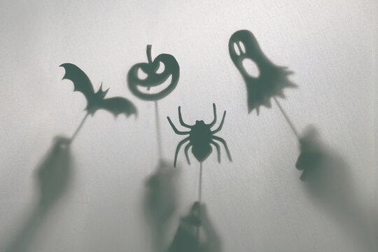 Halloween decoration. Children making terrifying shadow puppets.