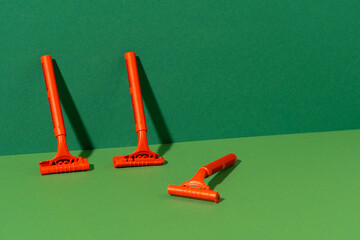Disposable razor on green background, studio shot