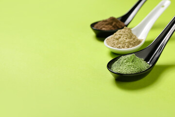 Spoons with henna on color background