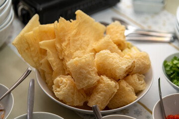 Homemade steamboat fried sliced tofu and ingredients served with hot chilly and spices on dressed table