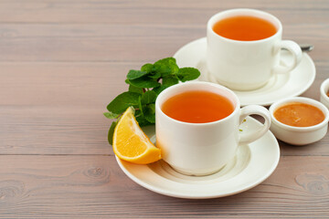 Cup of tea served with lemon and mint
