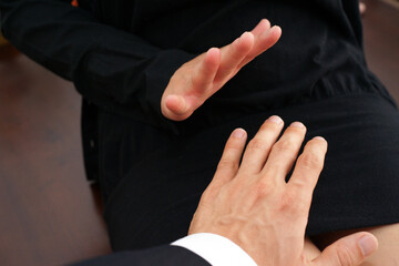 Businessman sexually harassing female colleague by trying to touch her