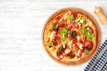 Pizza with ham and salad on wooden background
