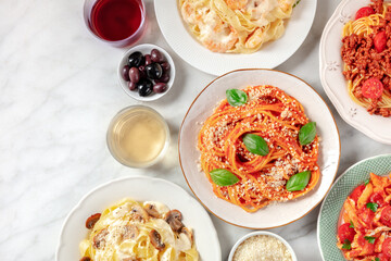 Italian food, shot from the top with a place for text. Pasta, olives, wine. Spaghetti with tomato sauce, ravioli, and other classics