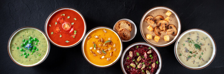 Vegan soup panoramic banner. Various vegetable soups, shot from above, a flat lay on a black...