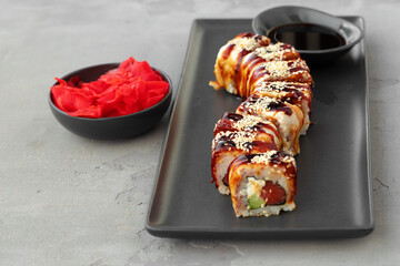 Dragon sushi roll with eel on black ceramic plate