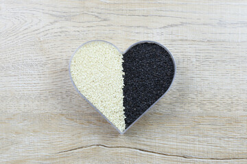 White and black sesame seeds in a heart shaped box and have copy space.