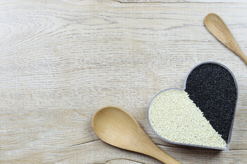 White and black sesame seeds in a heart shaped box and have copy space.
