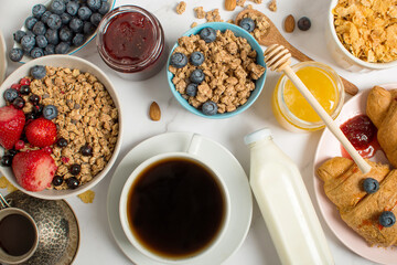 Breakfast table with oatmeal, croissants, fresh fruit