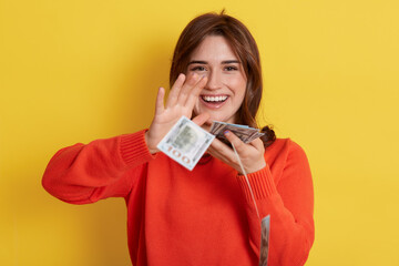Woman throws up cash, lottery winner with very happy expression, looking directly at camera and...