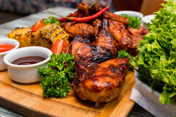 Barbecue chicken with vegetables on wooden table