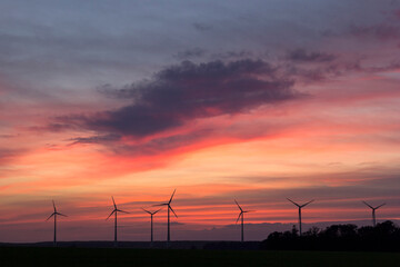 Obraz premium Wind Turbines at the field, Germany. A wind turbine is a device that converts the wind's kinetic energy into electrical power.