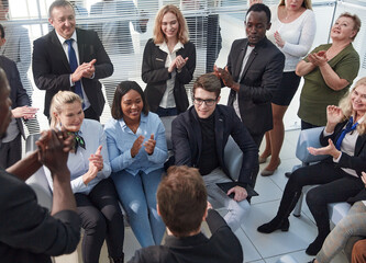 Office employees sit on chairs clap hands greeting presenter or speaker at group meeting close up.