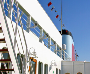 Weiß Roter  Schornstein von Kreuzfahrtschiff vor blauem Himmel - White and red cruiseship or...