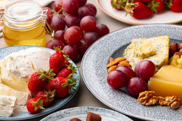 Composition of cheese, and fruits on gray table