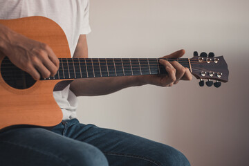 Closeup of hands working on an instrumental instrument while playing and singing at home due to...