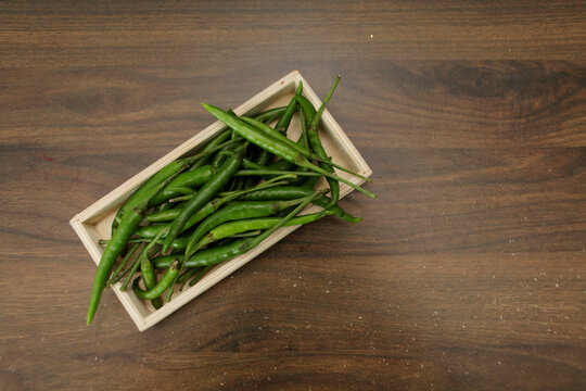 Green cili pepper heard on wooden box